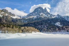 Le lac de Bious Artigues enneigé et le pic d'Ossau l'hiver (vue aérienne)//The snowy lake of Bious Artigues and the peak of Ossau in winter (aerial view)
