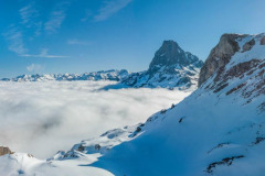 Le pic Casterau et le pic d'Ossau avec la neige et une mer de nuages (vue aérienne)//Pic Casterau and Pic d'Ossau with snow and a sea of clouds (aerial view)